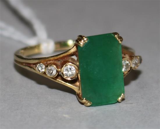 An 18ct gold, emerald and diamond ring, the 2.73ct emerald-cut stone flanked by diamond-set shoulders